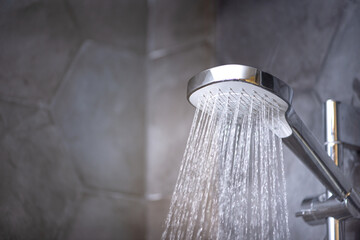 Closeup of shower head with running water in the bathroom - obrazy, fototapety, plakaty