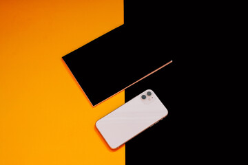 Close up glass, phone, notebook and mint on colors background 