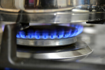 A stainless saucepan is placed on a gas stove, and the water is heated by household gas.