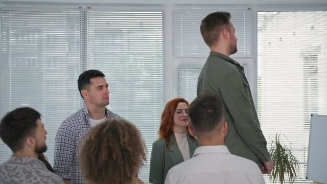 group therapy, a young man falls into the arms of his colleagues, and they applaud him during a psychotherapy session