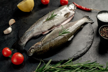 raw fish trout with spices ready for cooking, on a stone background