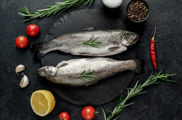 raw fish trout with spices ready for cooking, on a stone background