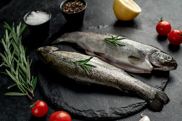 raw fish trout with spices ready for cooking, on a stone background