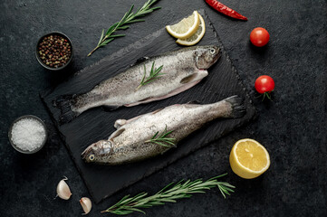 raw fish trout with spices ready for cooking, on a stone background