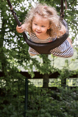 petite fille joue sur une balançoire, elle se balance et vole.
