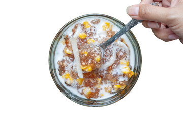 Top view of hand holding spoon scooping Tapioca pearl or Sago pudding with young coconut meat and coconut milk in cup is Thai desserts isolated on white background included clipping path.