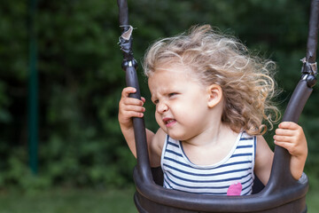 petite fille boude sur une balançoire