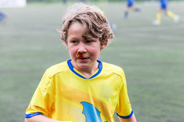 garçon enfant joue au foot et saigne du nez