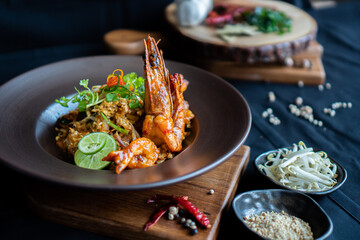 Pad Thai - stir-fried rice noodles with dried salt shrimp and tofu on wooden board - Asian food style