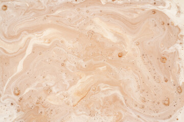 Coffee with milk texture. View from above. Delicious sweet treat.