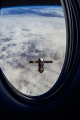 View on ISS Progress resupply ship, View out from a passenger window on the SpaceX Crew Dragon....