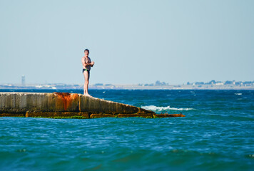 a man dives into the sea from the pier , Activities on the water