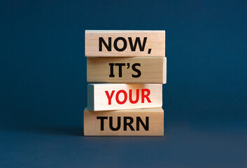 Now, it's your turn symbol. Wooden blocks form the words 'now, it's your turn' on beautiful grey background. Businessman hand. Beautiful background. Business, motivational and your turn concept.