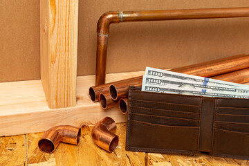 Copper plumbing pipe and money in wallet. Construction, repair and home maintenance cost concept