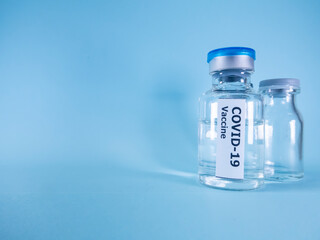 Covid-19 vaccine bottle on blue background.