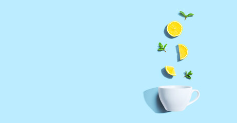 Fresh yellow lemons with tea cup overhead view