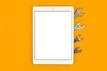 Construction service mockup screen, tablet on the table with proffesional tools, orange background, top view, flat lay and copy space photo