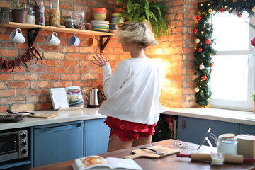The blonde girl is relaxing in the kitchen and shooting photos