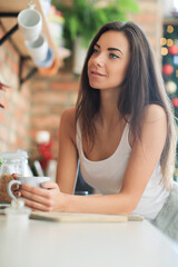 The blonde girl is relaxing in the kitchen and shooting photos