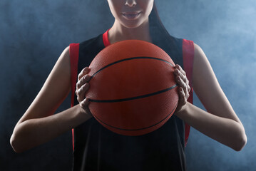 Basketball player with ball on black background, closeup