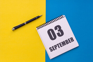 September 3rd. Day 3 of month, calendar date. Notebook with a spiral and pen lies on a yellow-blue background