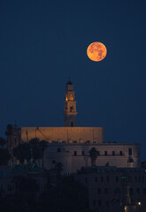 Blood Moon next to a clock tower