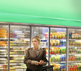 Woman choosing frozen food from a supermarket freezer..