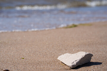 Fototapeta na wymiar washed small white stone in the sand of the sea shore