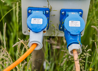 Electric hook up plugs inserted in to socket on a campsite