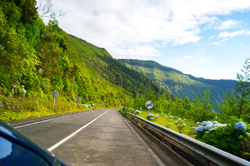 Lonely road to a green mountainous landscape in Sao Miguel, Azores.