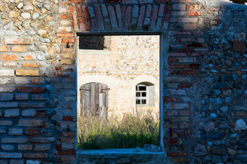 Vecchia finestra aperta su un antico muro di mattoni della vecchia casa abbandonata e disabitata.