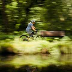 Woman cycling at speed by a canal