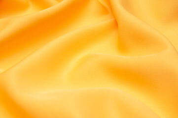 Smooth elegant yellow tissue abstract background. Textile background. Cloth wallpaper. Graphics design element