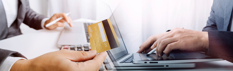 businesswoman hand using smart phone, tablet payments and holding credit card online shopping, omni channel, digital tablet docking keyboard computer at office in sun light