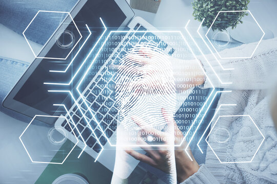 Double exposure of woman hands working on computer and fingerprint hologram drawing. Top View. Digital Security concept.