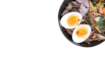 Studio shot of black bowl of ramen noodles with boiled eggs, veggies and turkey meet, ready to be poured with boiling broth isolated on white background.