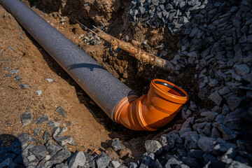 sewer pipe with a diameter of 110 millimeters in thermal insulation, laid in a trench of sand and gravel mixture - obrazy, fototapety, plakaty