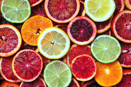 Slices of red sicilian oranges, tangerine, lemon and lime background