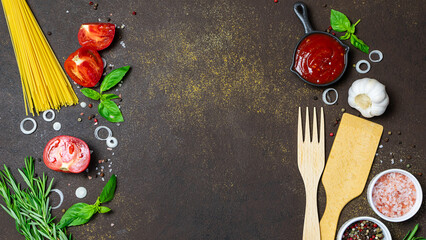 Set of spices, herbs, raw spaghetti and vegetables on dark rustic background with copy space for your design. Cook book cover template.