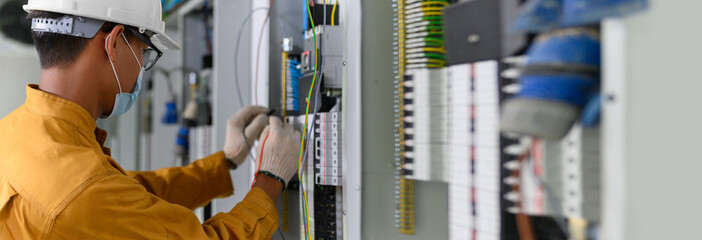 Electrician engineer using digital multimeter test current electric in control panel ​for testing...