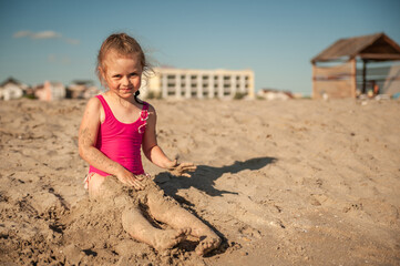 Cute little girl playing in the sand