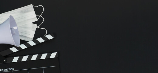 Black clapper board or movie clapperboard or slate and magaphone on black background.it use in...