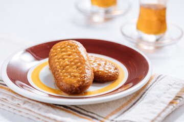 Bosnian and Turkish dessert called Hurmasica served on a grey background with cup of coffee