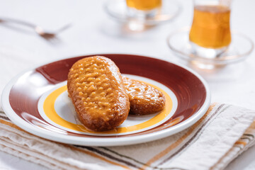 Bosnian and Turkish dessert called Hurmasica served on a grey background with cup of coffee