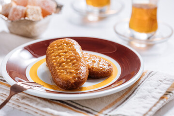 Bosnian and Turkish dessert called Hurmasica served on a grey background with cup of coffee