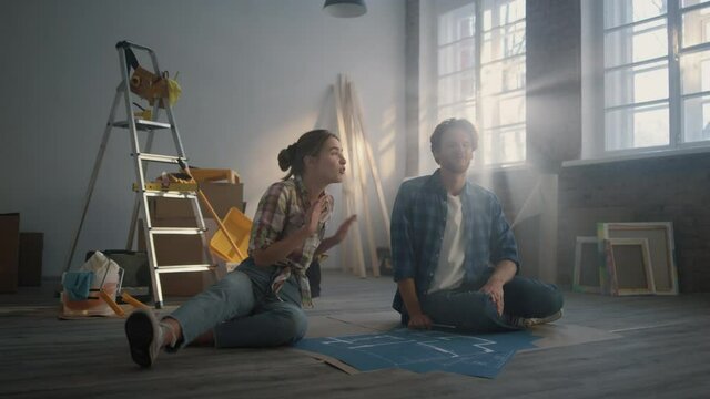 Family watching design project indoors. Couple discussing idea of home repair.