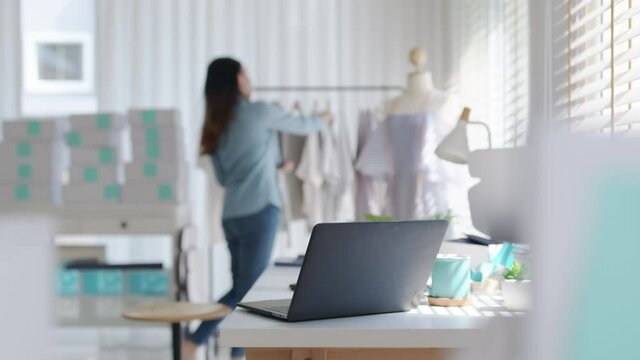 Digital tablet computer or laptop on home office desk with asia freelance seller woman happy packing check busy work in fashion studio SME online store social e-commerce sale page service web support.