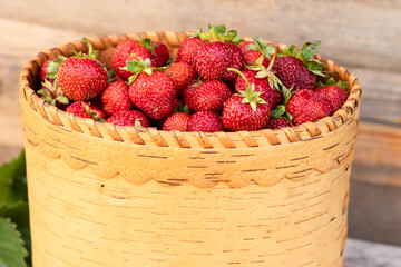 strawberries in a basket of birch on an old wooden background