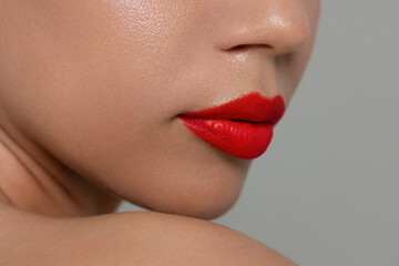 Fototapeta premium Close-up of woman's lips with fashion bright red make-up. Beautiful female mouth, full lips with perfect makeup. Part of female face. Choice lipstick
