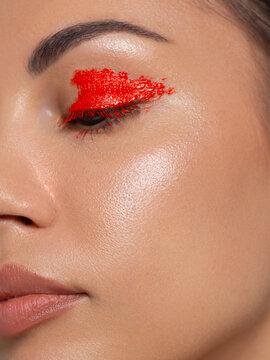 Close-up shot of woman lips with red lipstick. Beautiful perfect lipstick. Sexy mouth close up and extram eyelashes. Beautiful wide lips of young fresh woman with full lips and eyeliner on eyes.